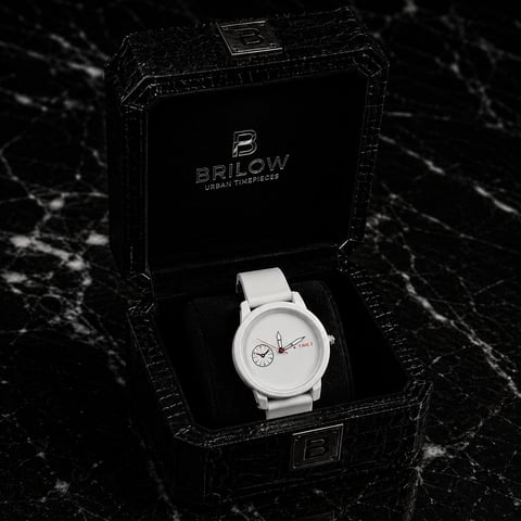 White Brilow watch with minimalist dial displayed in black textured presentation box on marble surface