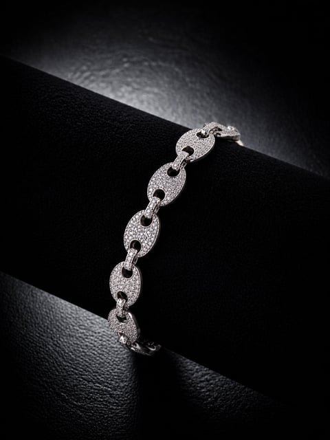Elegant silver bracelet with oval link chain studded with diamonds, displayed on black fabric