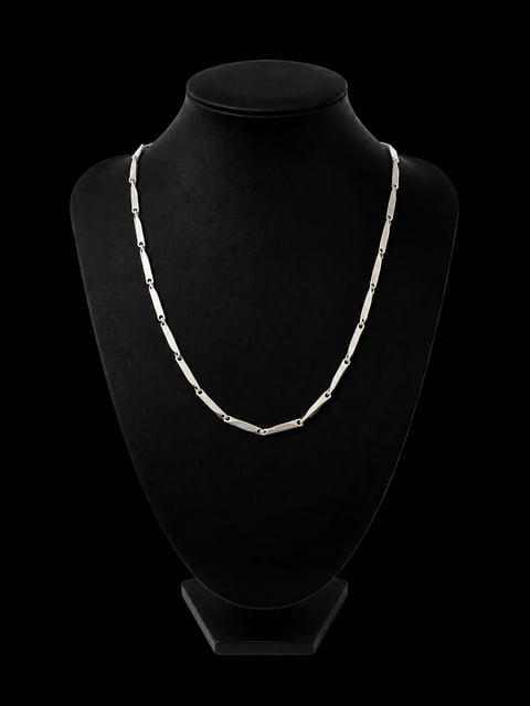 Silver chain necklace displayed on a black mannequin bust against a dark background