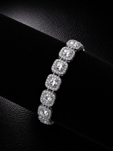 Elegant diamond tennis bracelet with cushion-cut stones and halo settings displayed on black leather