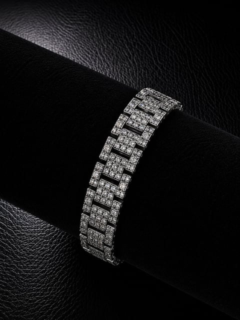 Luxury diamond-encrusted bracelet displayed on black leather against textured dark background in black and white photography
