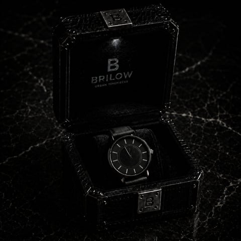 Brilow luxury watch displayed in black leather presentation box with metal clasps on dark marble surface