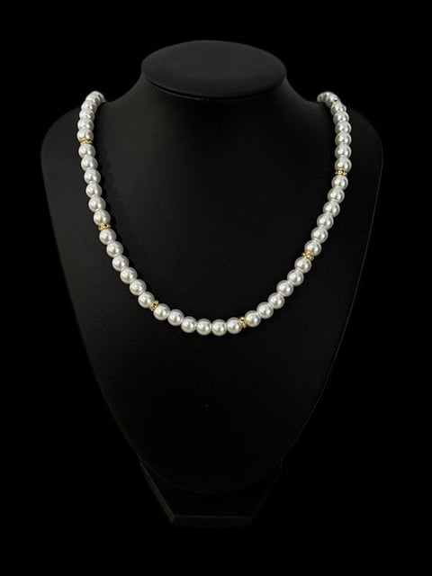 White pearl necklace displayed on a black mannequin stand