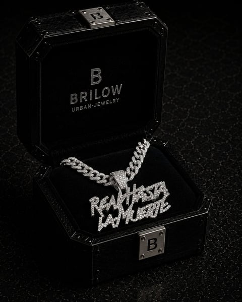 Brilow Urban Jewelry black display box with diamond-encrusted chain necklace pendant spelling Real Hasta La Vega