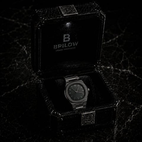 Brilow stainless steel watch displayed in open black luxury box on dark marble background