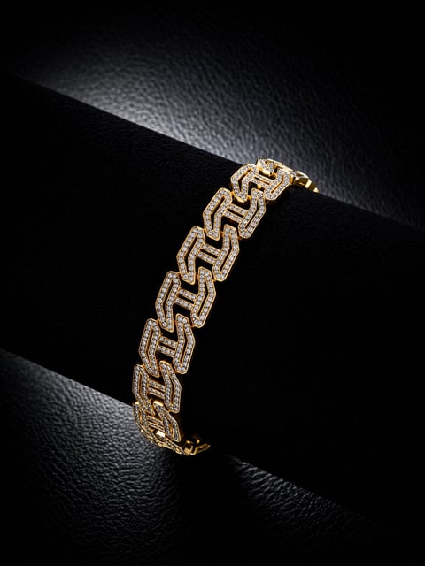 Gold and diamond geometric link bracelet displayed on black textured surface with dramatic lighting