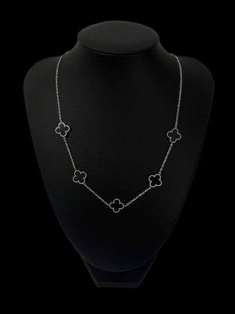 Silver clover station necklace with five open four-leaf clover charms displayed on black mannequin bust