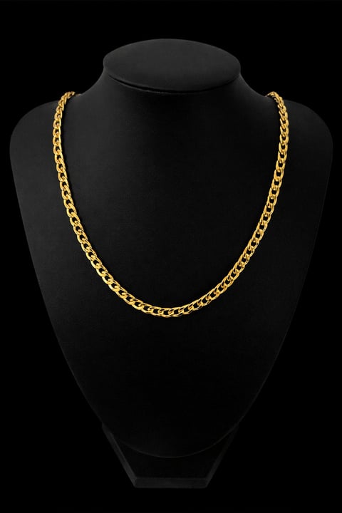 Gold chain necklace displayed on a black mannequin bust against a dark background
