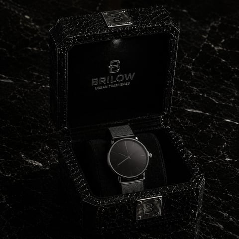 Brilow luxury watch with black mesh band displayed in open branded box on marble surface
